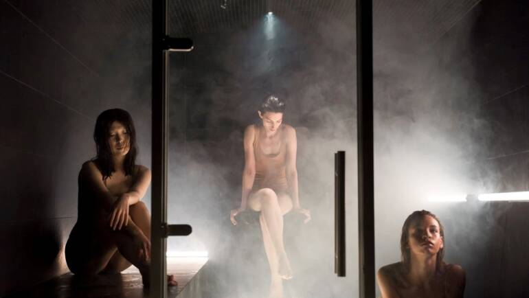 Three people in a sauna steam room