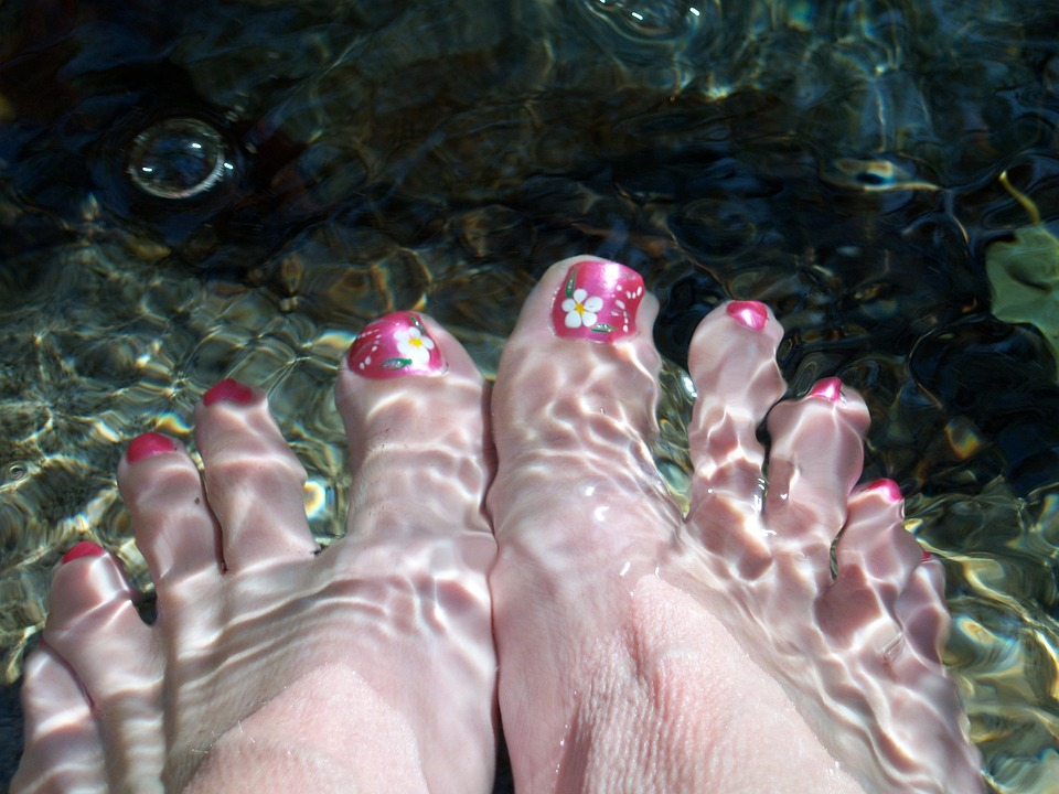  feet with painted toenails dipped in water  