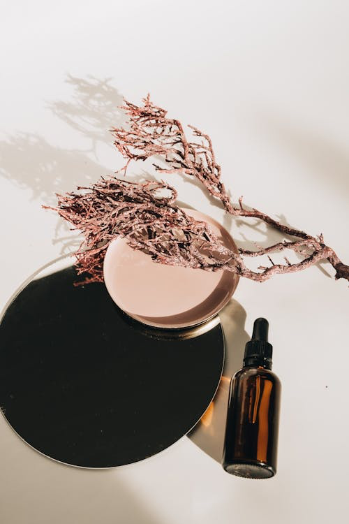 An image of a brown glass bottle placed next to circular containers