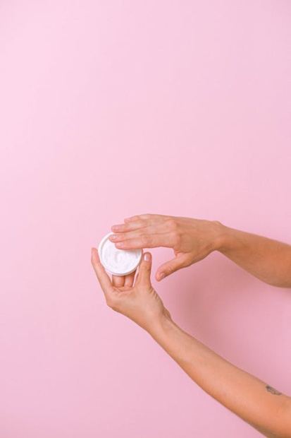 An image of a person taking out some cream from a container